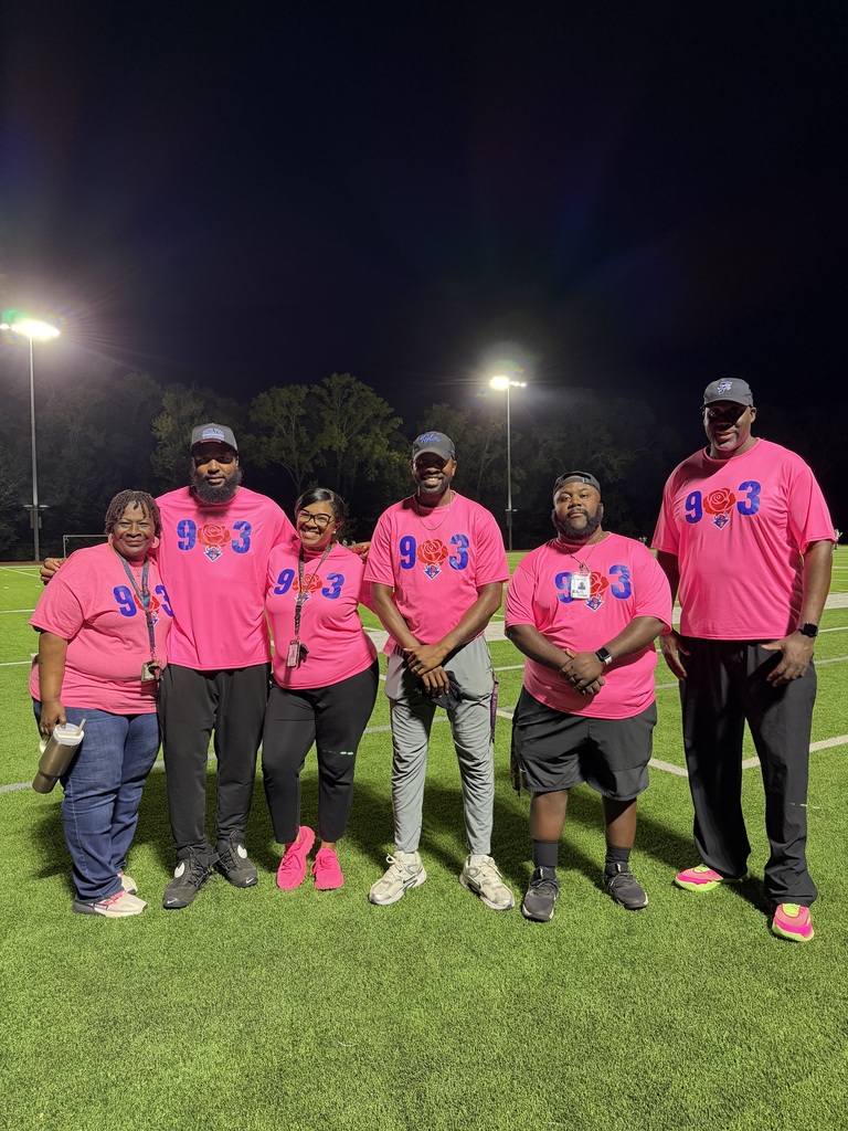 Teachers and coaches in pink at football game 