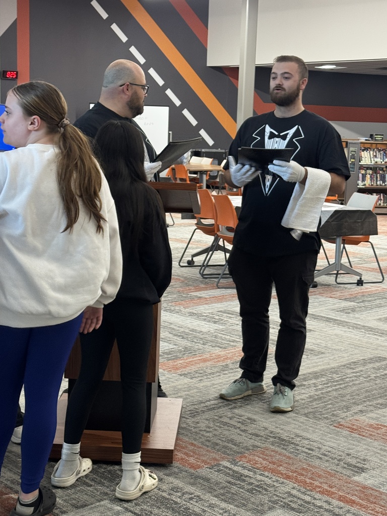 host and waiter greeting a group of students