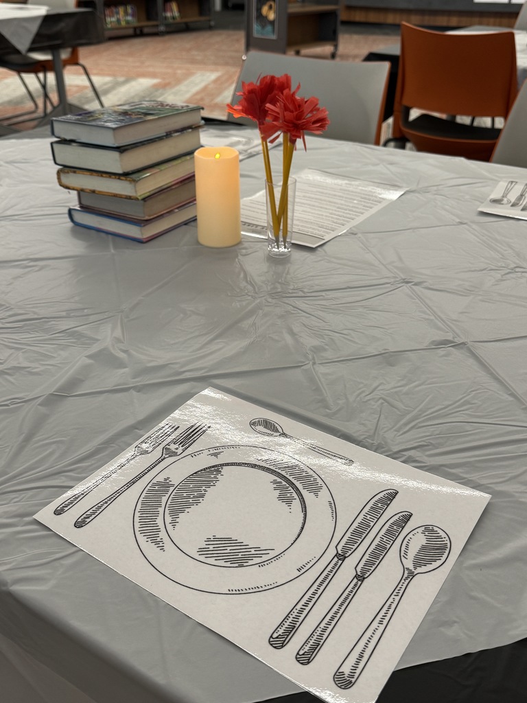 table set for book tasting with a candle and flowers