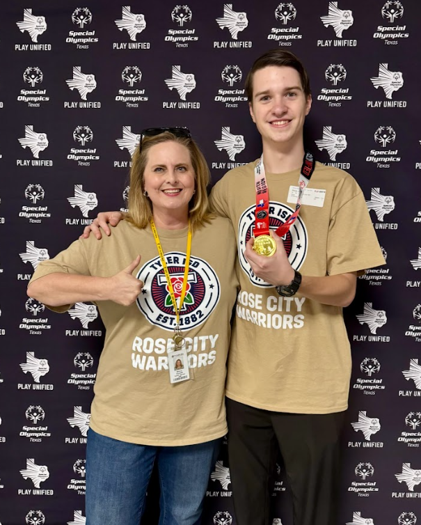 Rose City Warrior teacher and student smile together while student holds up medal.