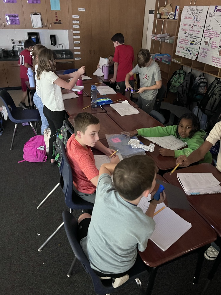 kids sitting at desks using flashlight