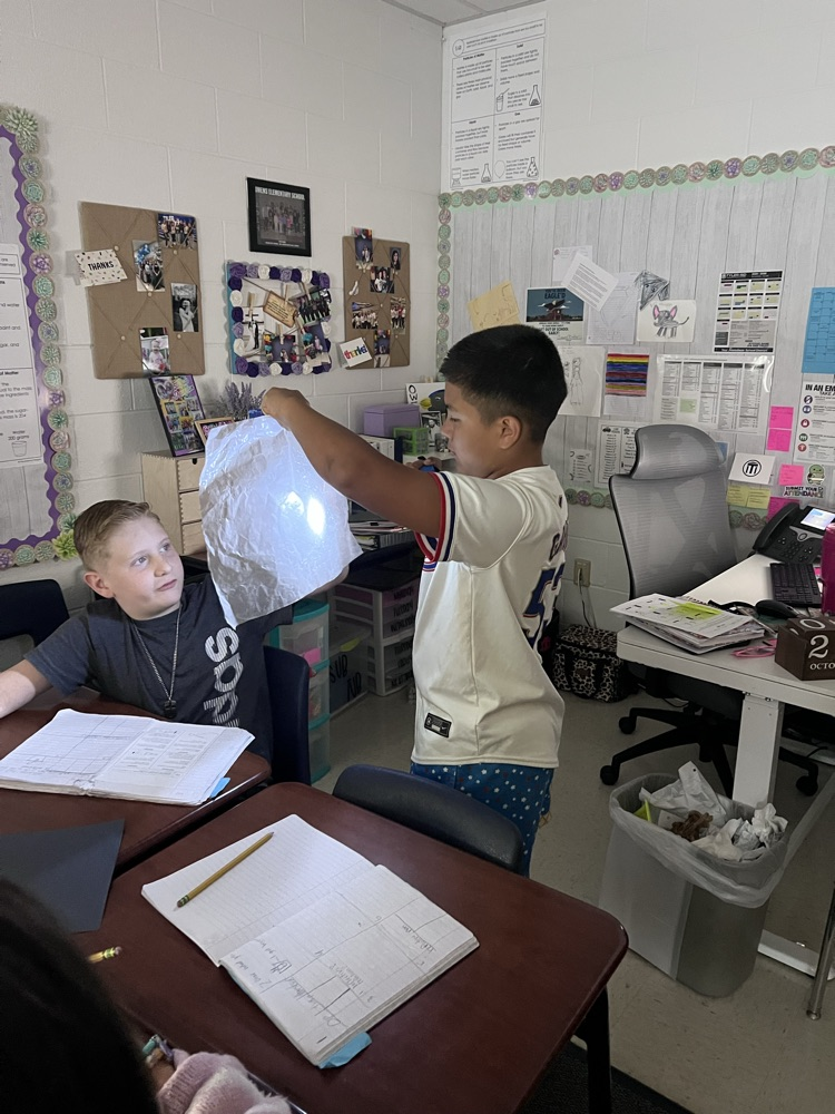 students working at desks with flashlights