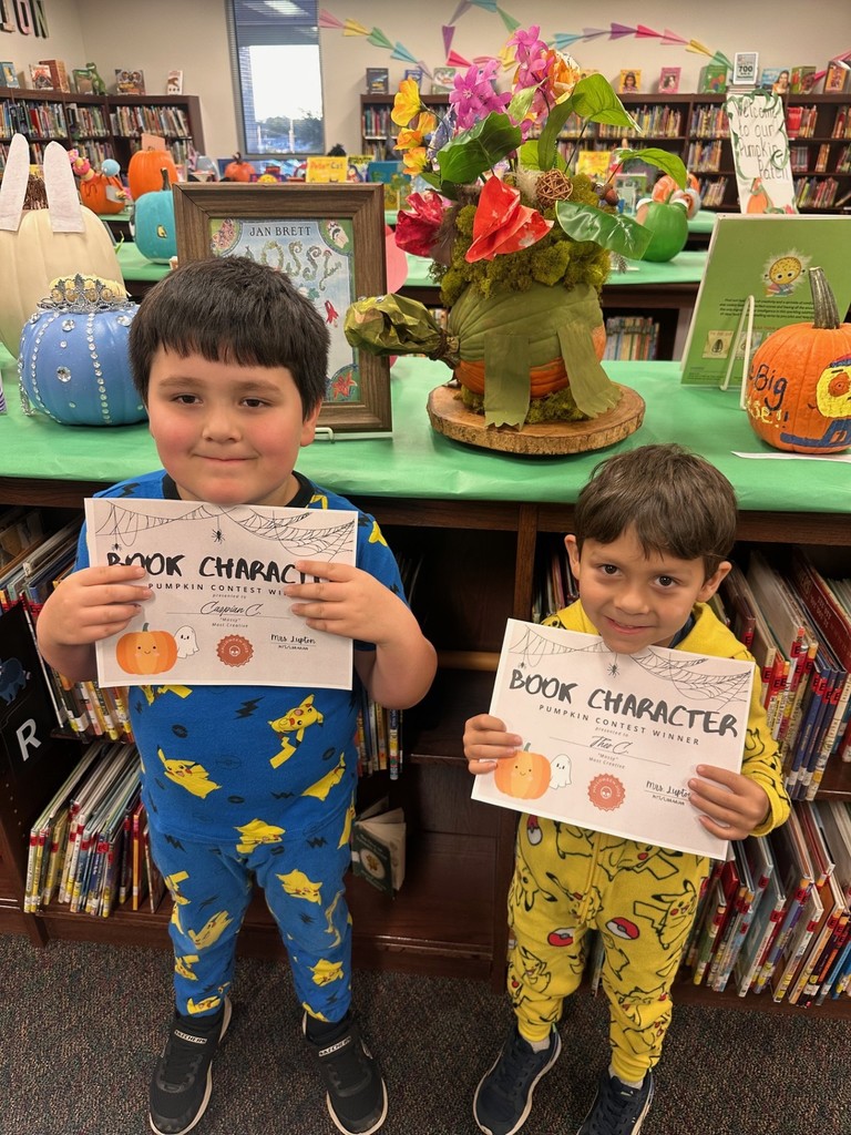two boys with decorated pumpkin and certificate