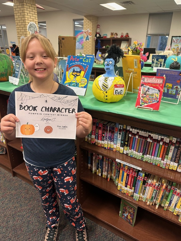 Girl with decorated pumpkin and certificate