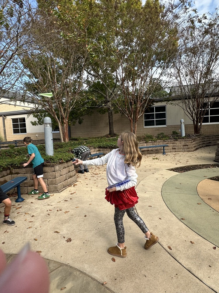 A girl flying a paper airplane
