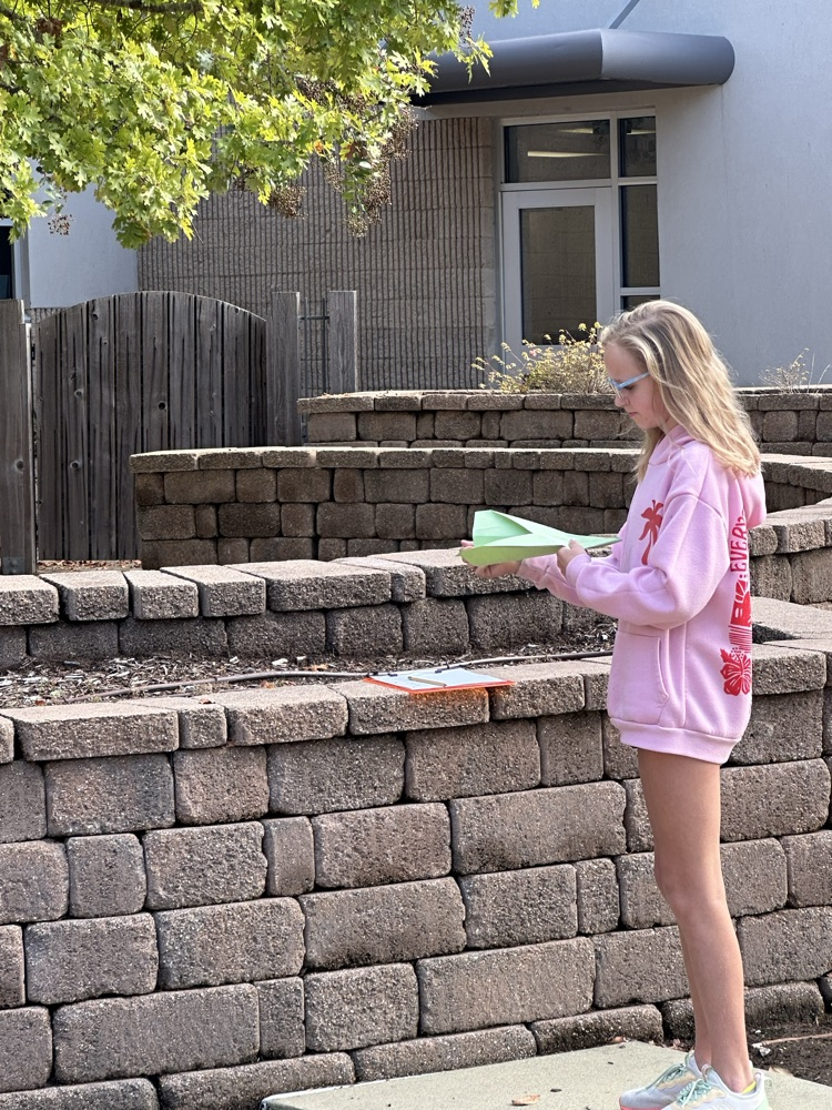 a girl folding a paper airplane