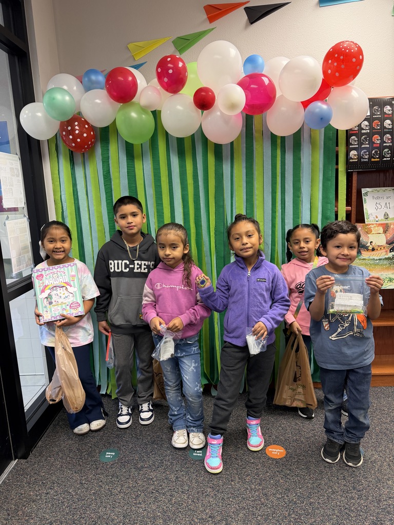 Children holding books and items from Book Fair