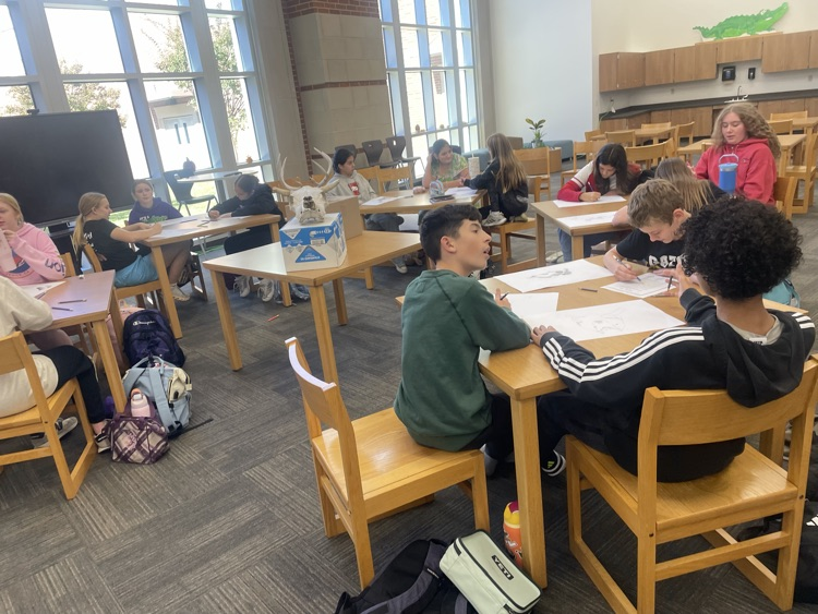 Students drawing in the library.