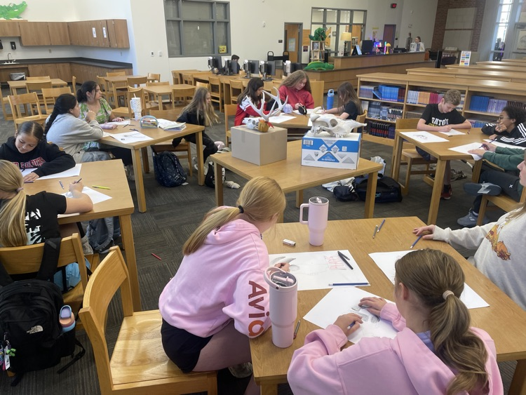 Students drawing in the library.