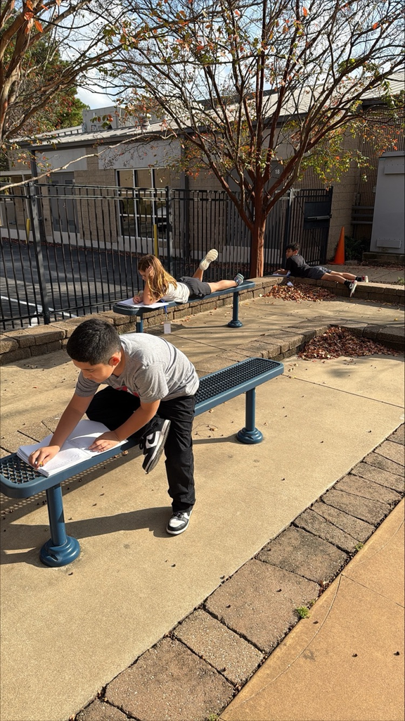 kids sitting outside writing 