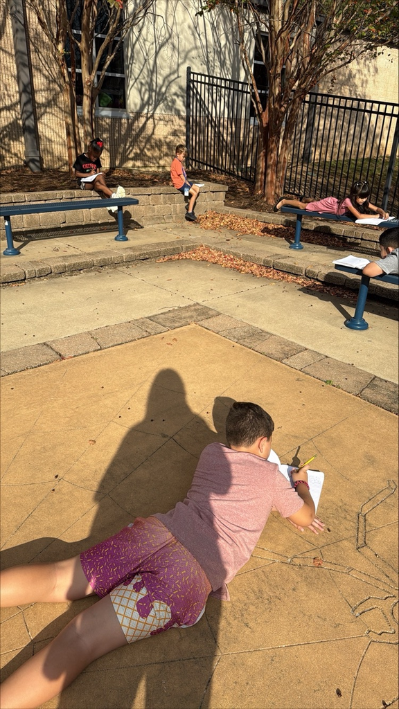 kids sitting outside writing 