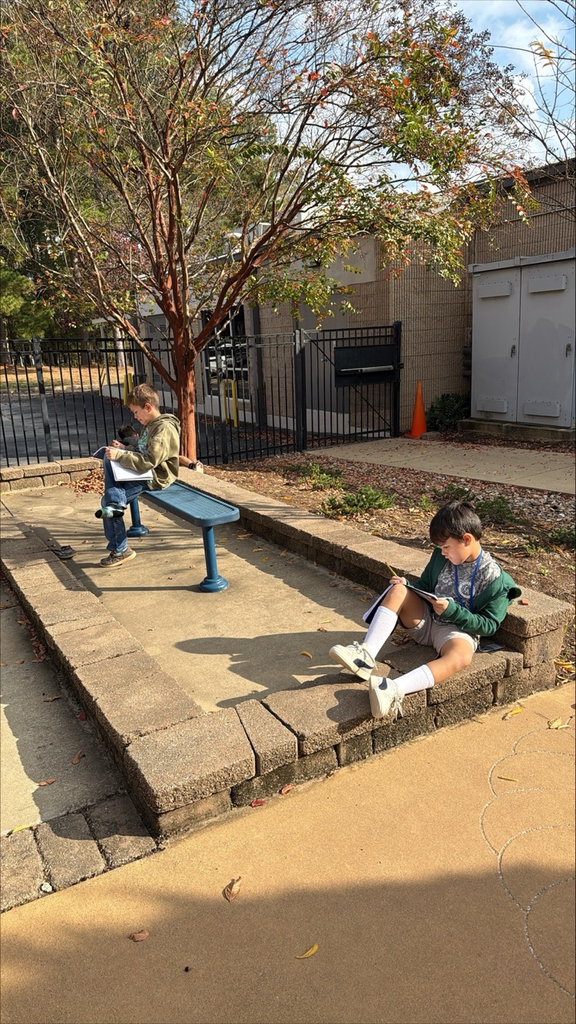 kids sitting outside writing 