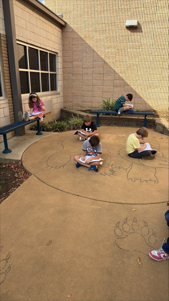 kids sitting outside writing 