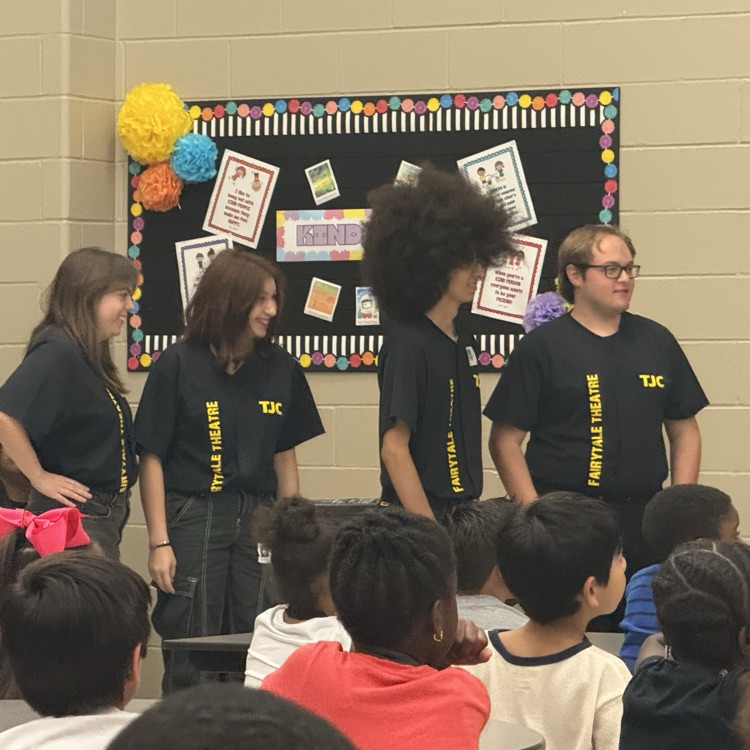 students watching a fairy tale play on stage in the cafe