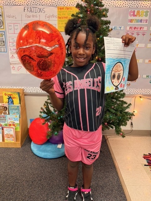 Student holding decorated balloons