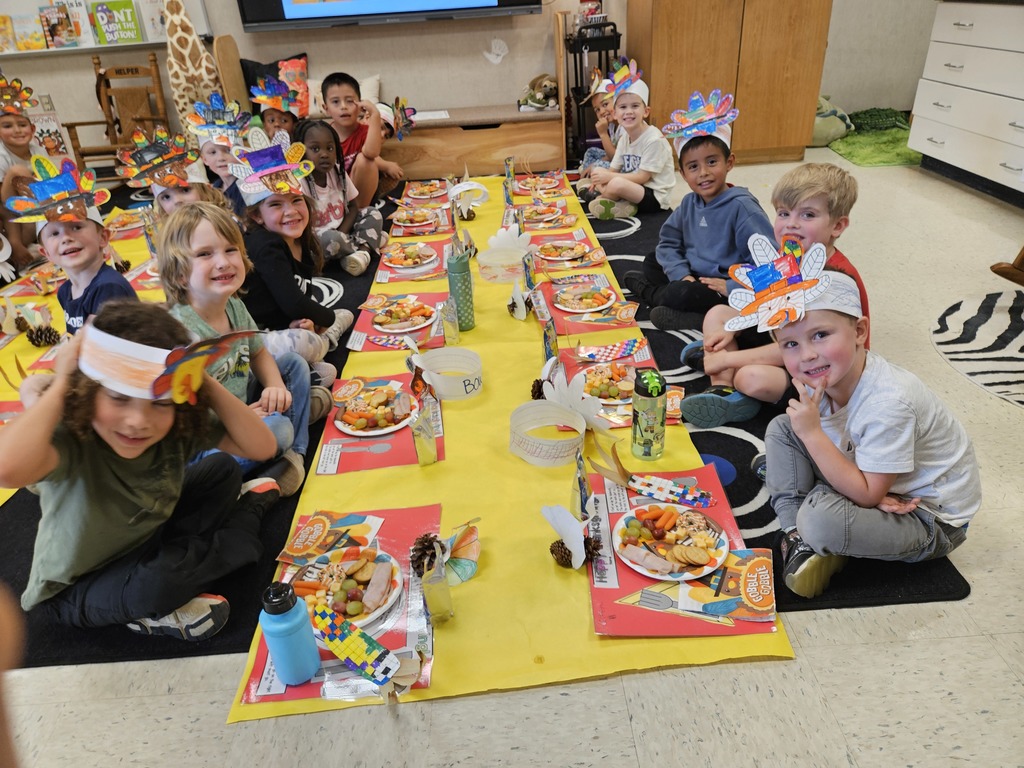 Kindergarten students eating a Thanksgiving snack with cute placemats and turkey hats. 