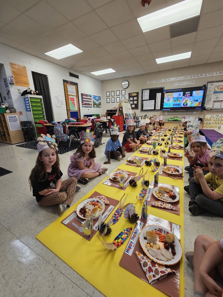 Kindergarten students eating a Thanksgiving snack with cute placemats and turkey hats. 
