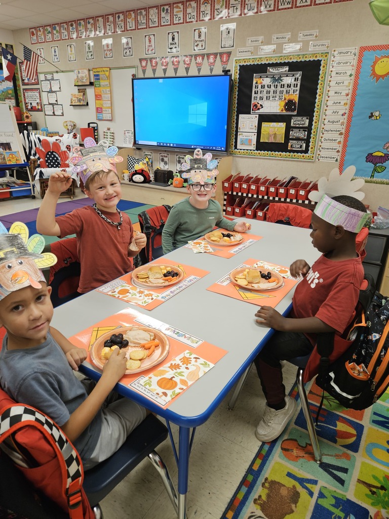 Kindergarten students eating a Thanksgiving snack with cute placemats and turkey hats. 