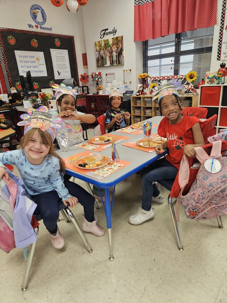 Kindergarten students eating a Thanksgiving snack with cute placemats and turkey hats. 