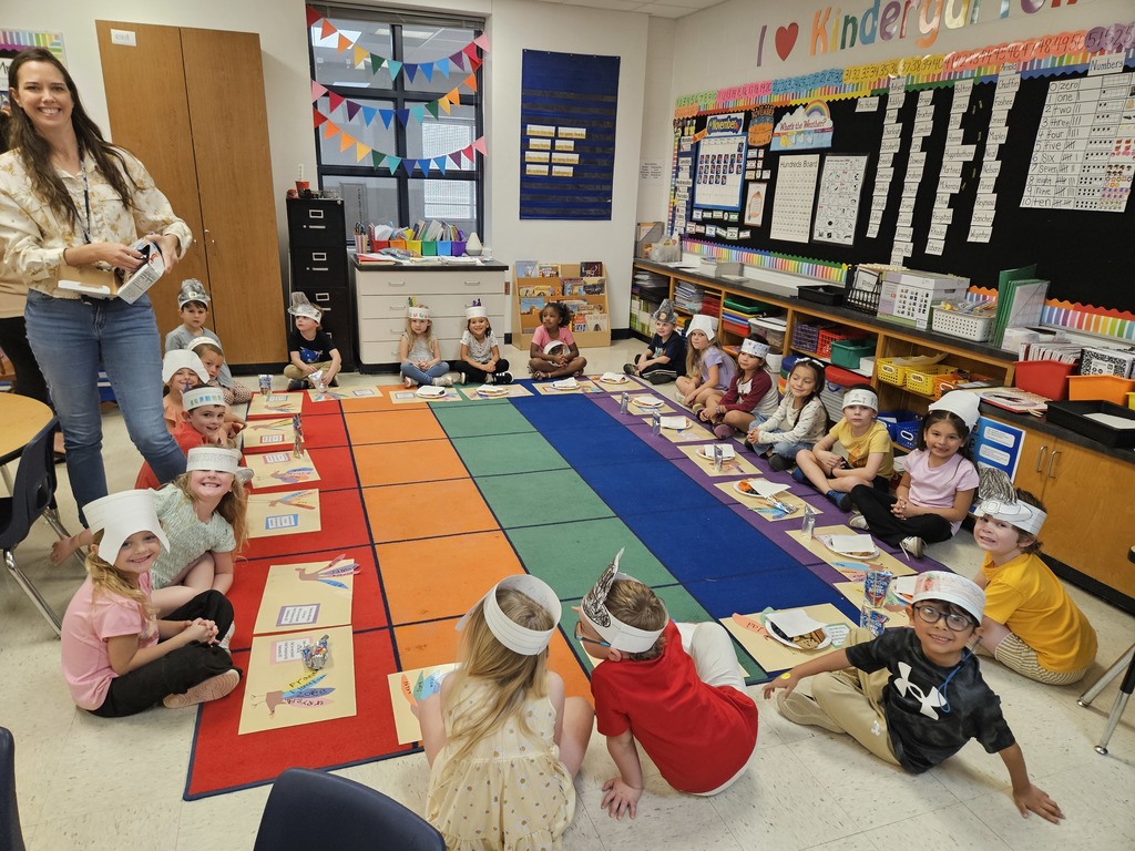 Kindergarten students eating a Thanksgiving snack with cute placemats and turkey hats. 