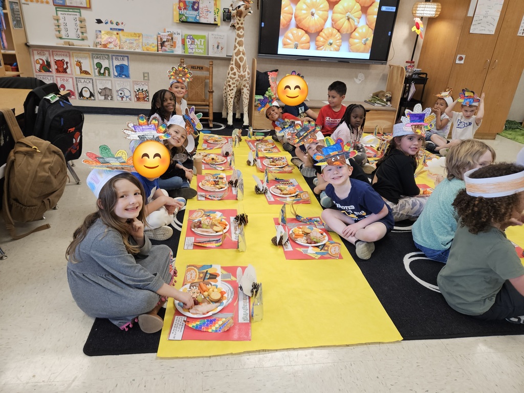 Kindergarten students eating a Thanksgiving snack with cute placemats and turkey hats. 