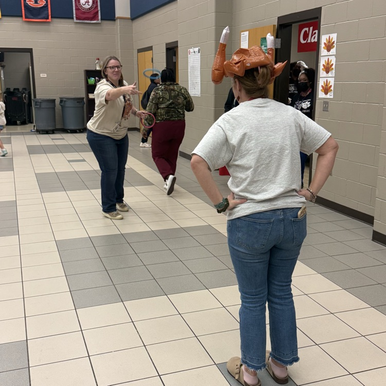teachers throwing rings at woman’s turkey hat