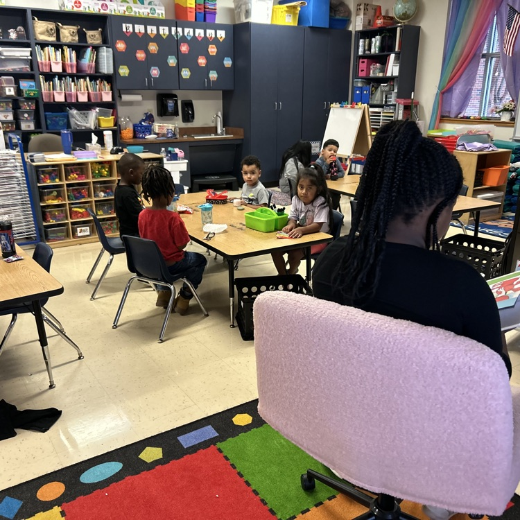 Fourth grade student reading to pre-K students during snack time