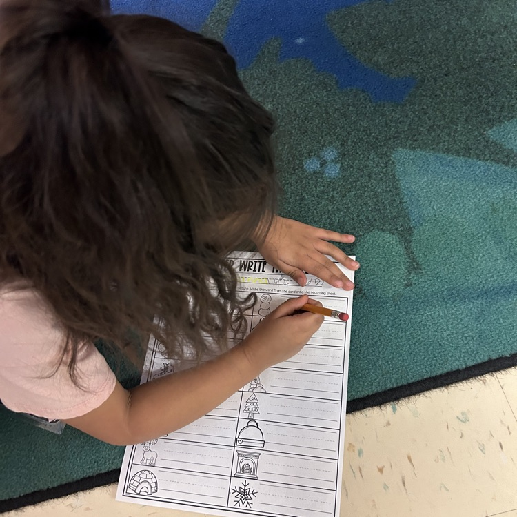 Pre-K student riding winter words around the room