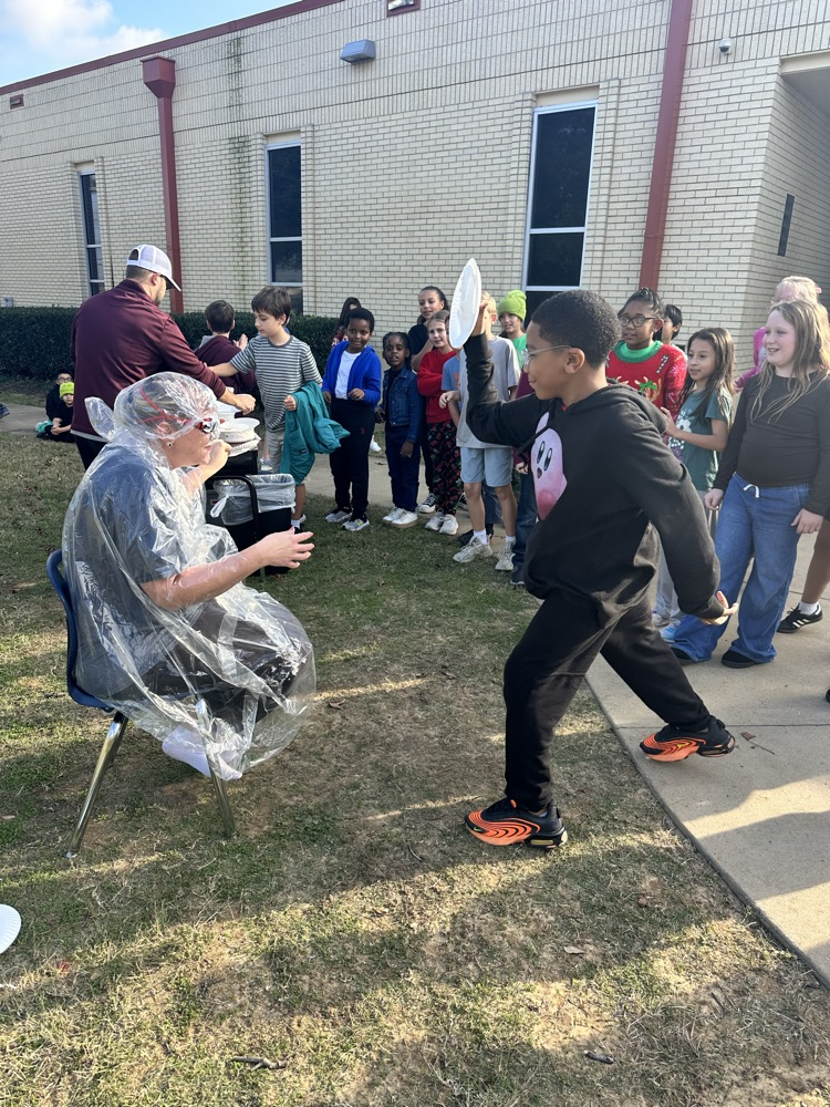 students throwing pies at Mrs. Harville