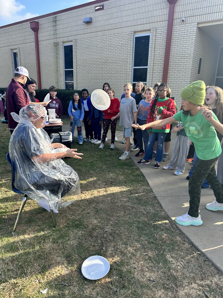 students throwing pies at Mrs. Harville