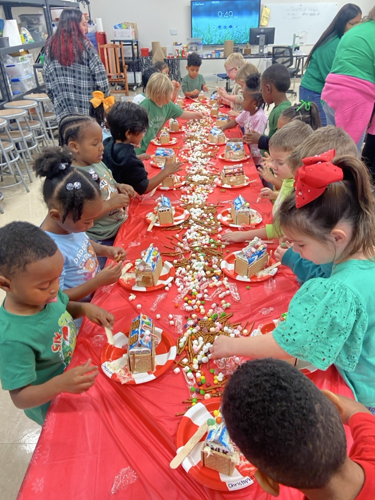Kids making gingerbread houses.