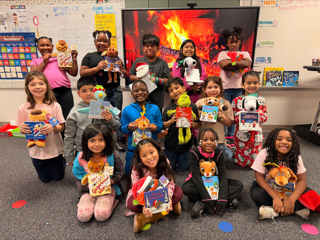 Students holding book and stuffed animal!