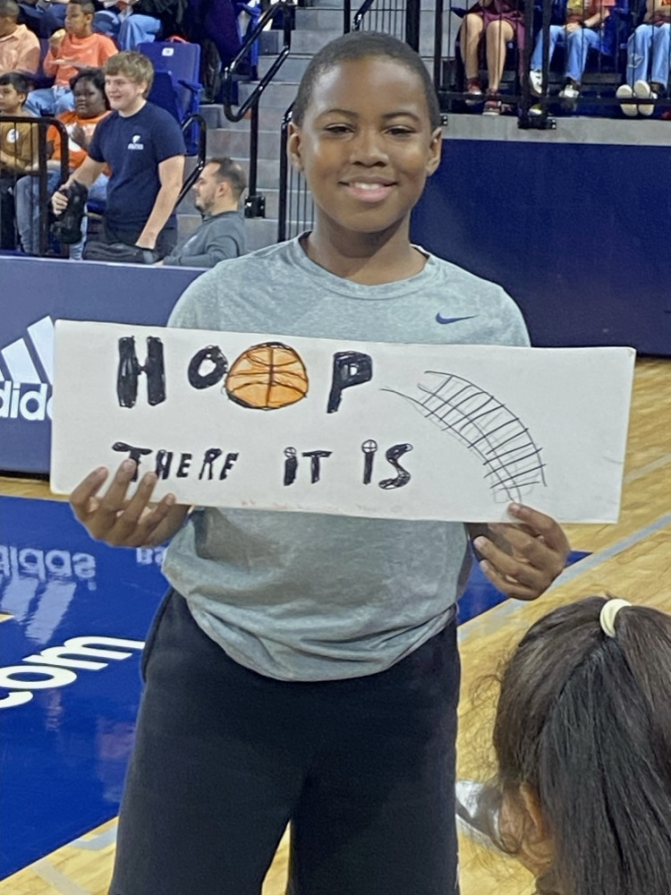 student smiling holding a sign
