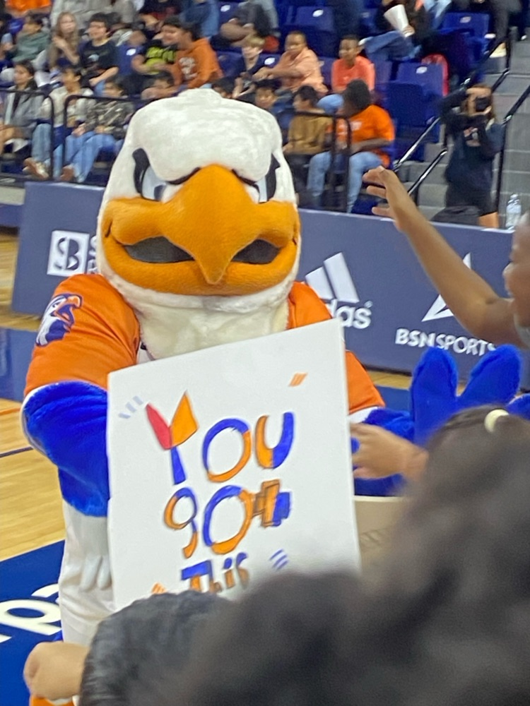mascot holding a sign