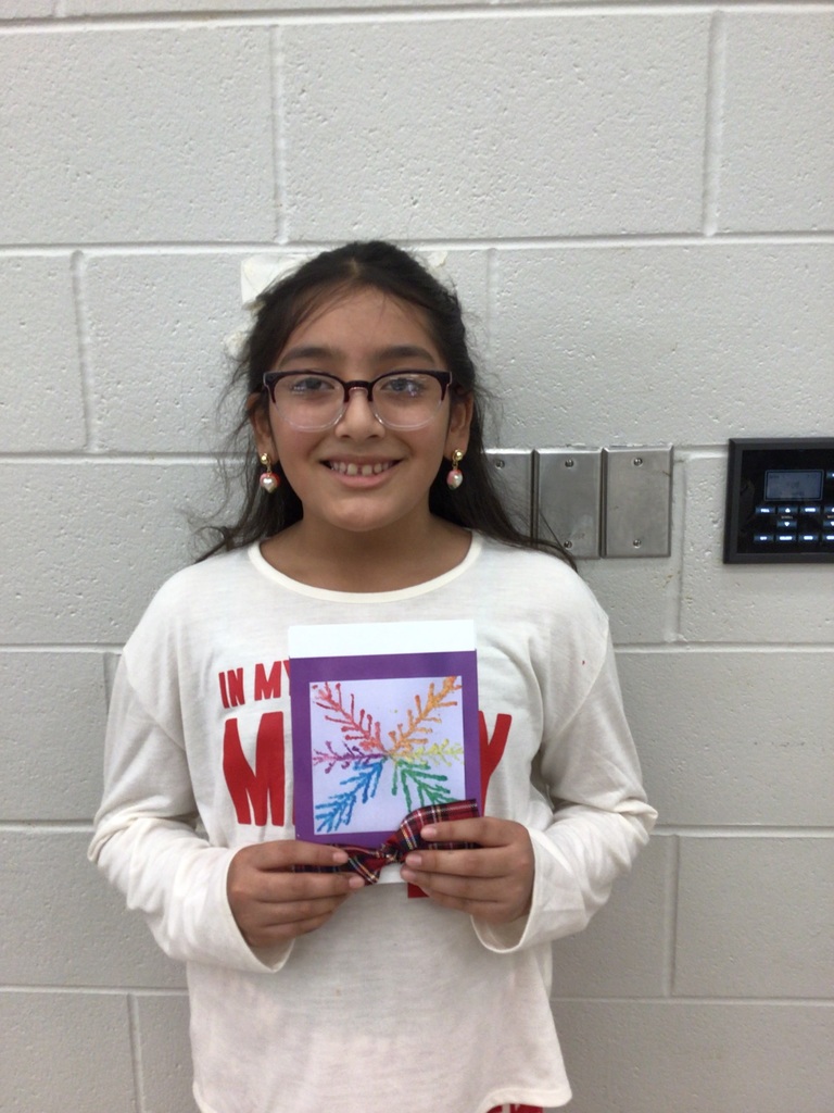 Students standing with their artwork made for Christmas Cards.