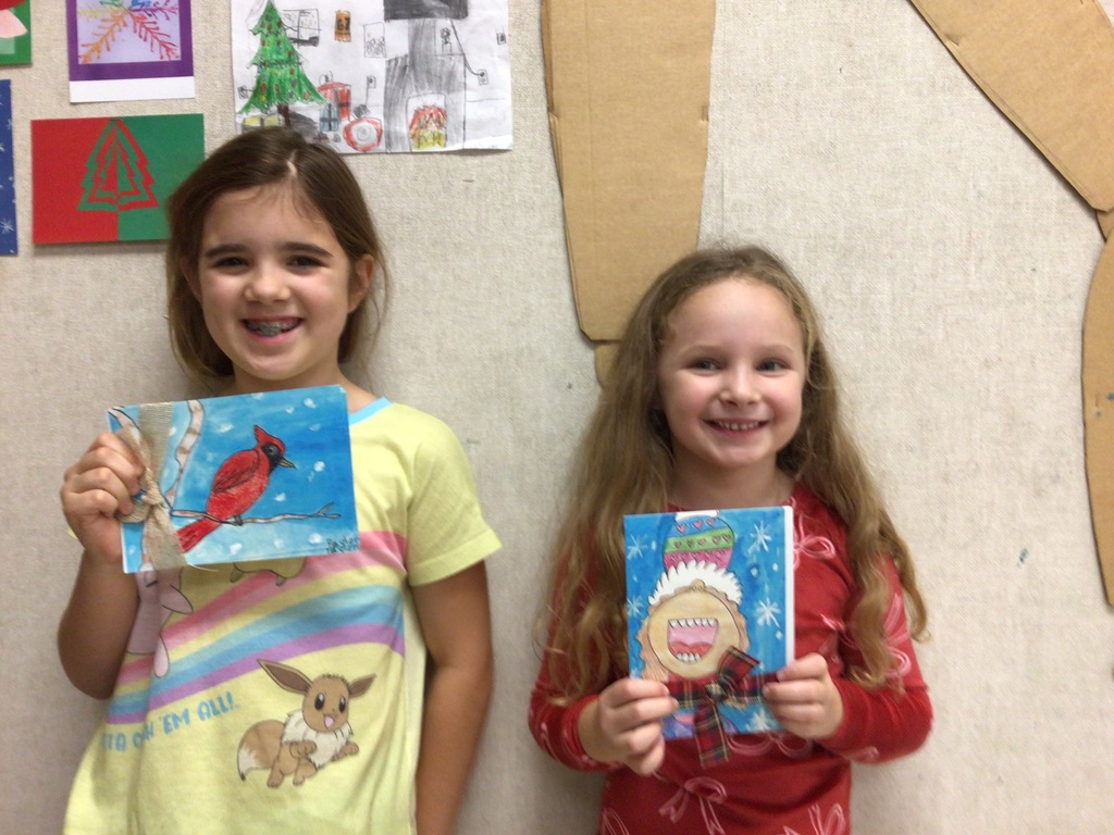 Students standing with their artwork made for Christmas Cards.
