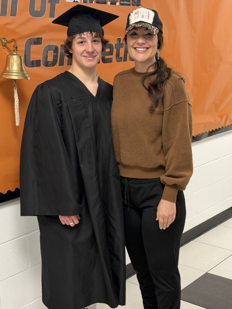 student posing with his mother