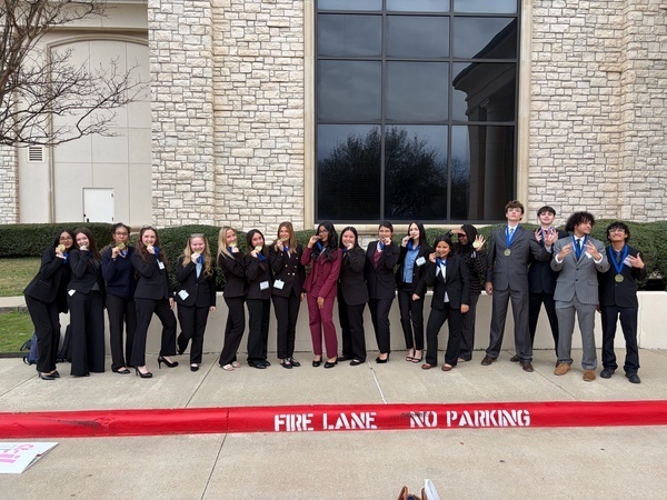 TISD DECA students at their district competition with their competition medals