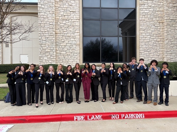 TISD DECA students at their district competition with their competition medals