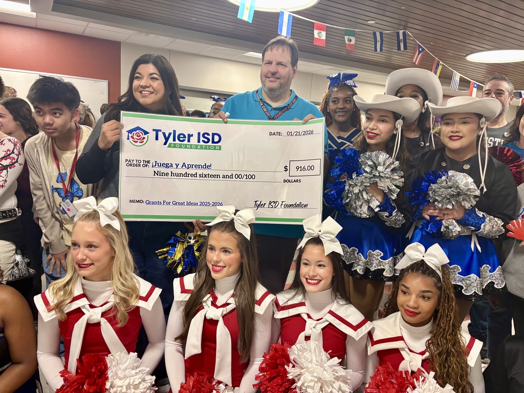 Mr. Kellerman and Varsity cheerleaders posing with his big grant check