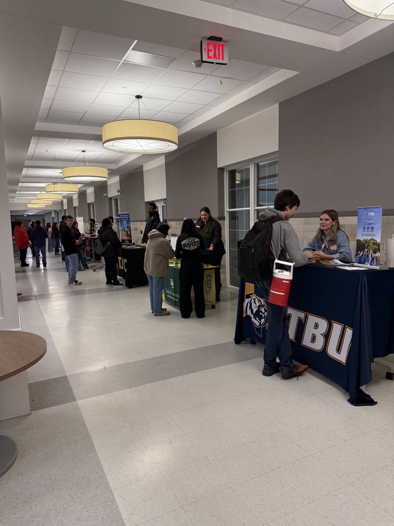 Students and families at the College tables asking questions