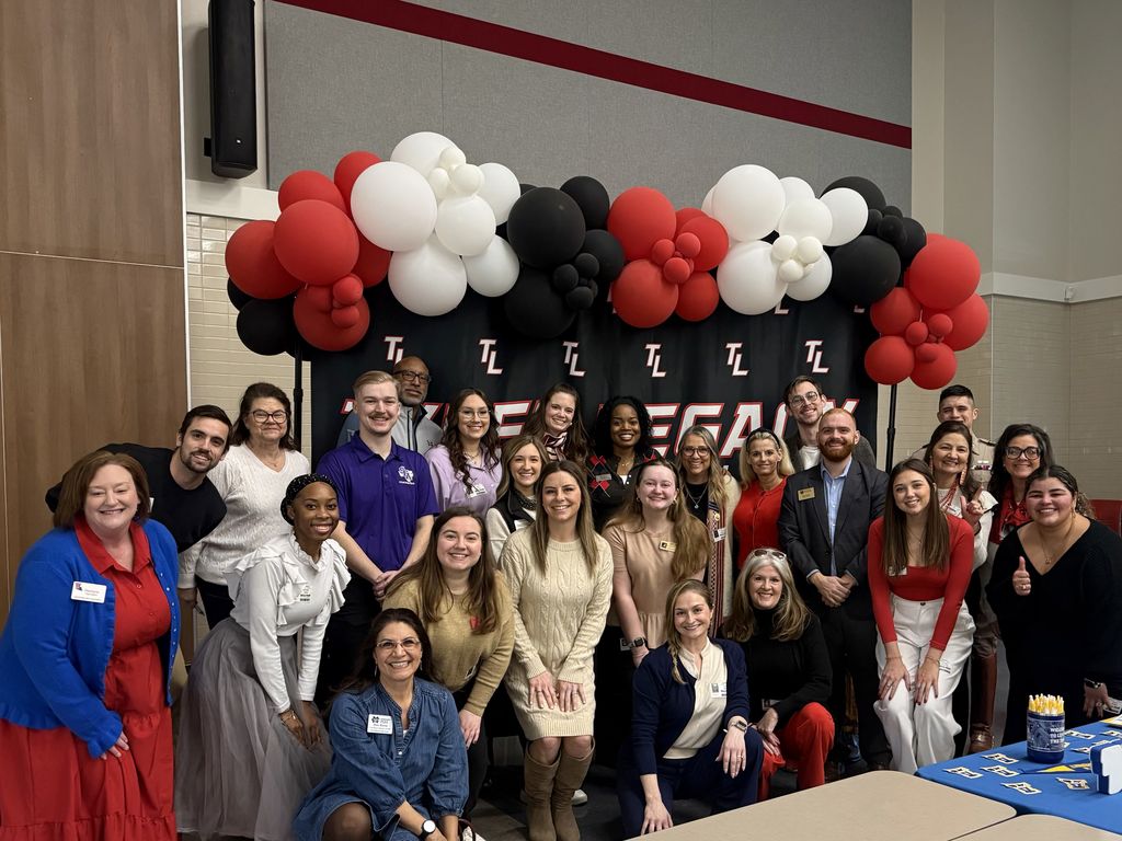 Tyler Legacy's Career and College Counselor, Mrs. Jones, with representatives from all the colleges at the DARN college fair in front of a Tyler Legacy backdrop