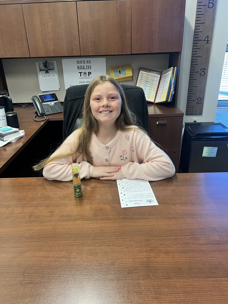Student sitting at principal desk  