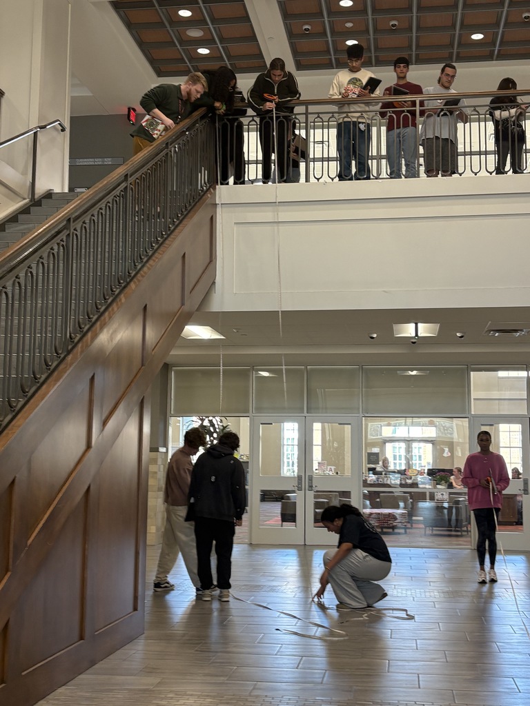 Mr. Smith helping students calculate bullet trajectory on the stairs