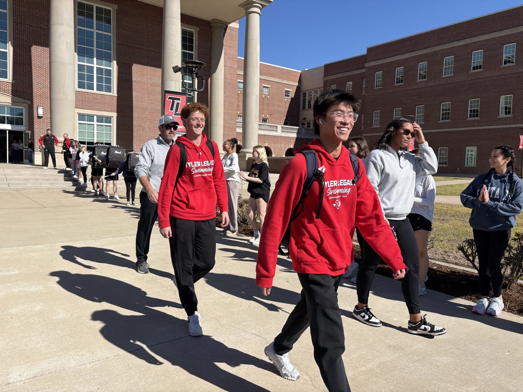 Swimmers walking out of Tyler Legacy during the send off for regionals