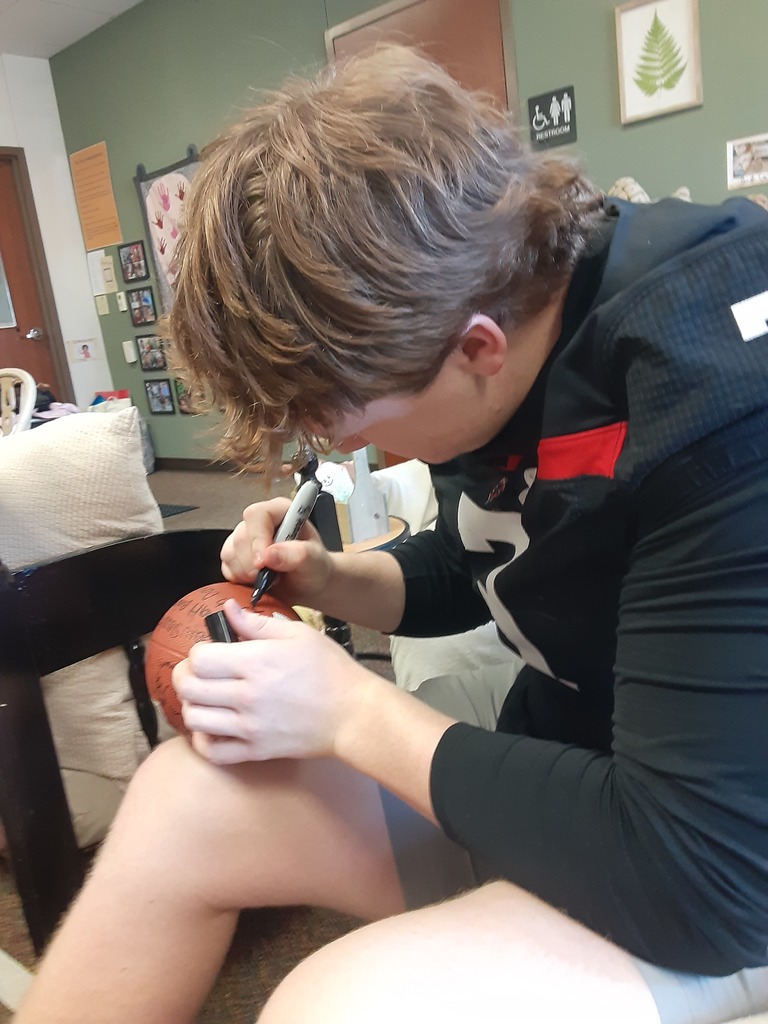 High School Football player signing a football