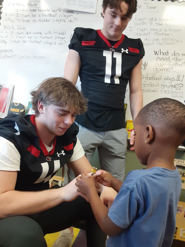 Child giving a football player a ring