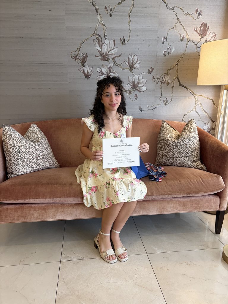 Tyler Legacy senior, Mya Flack holding up her scholarship cedrtifcate 