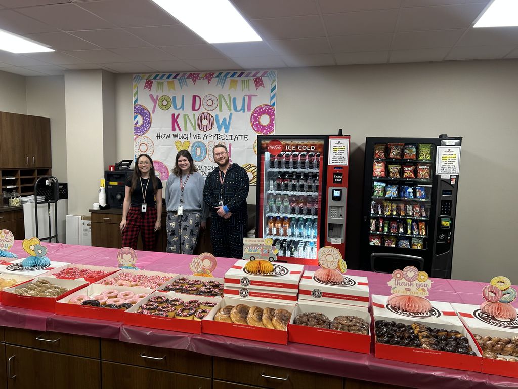 Tyler Legacy teachers posing behind a table full of donuts