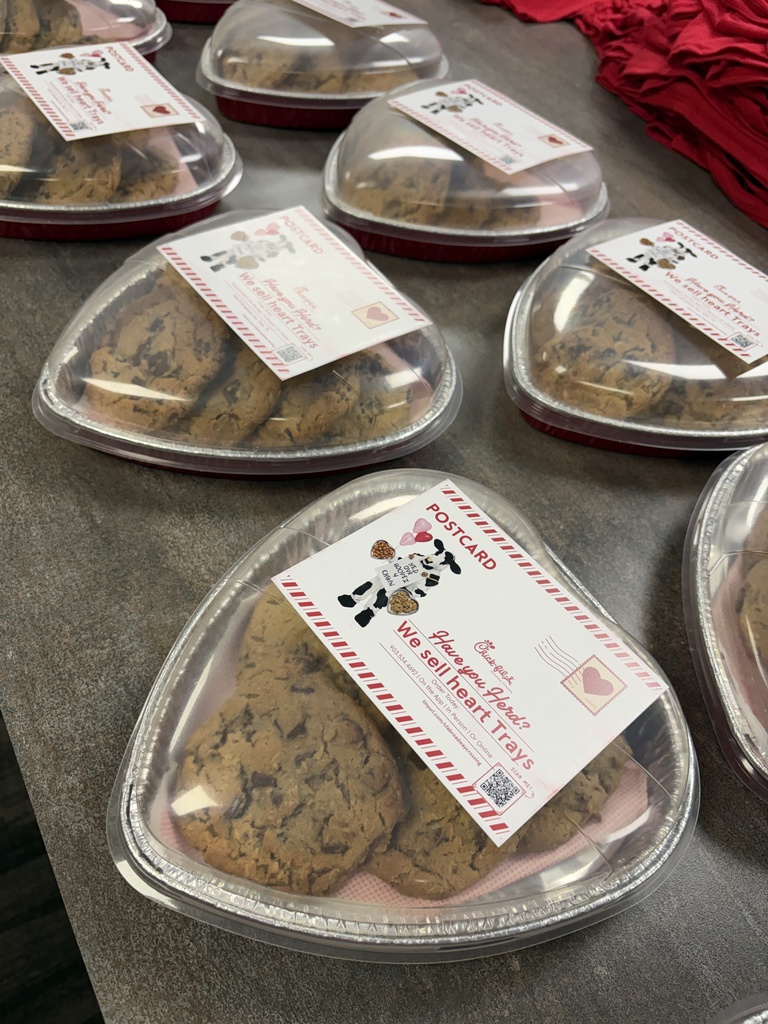 A heart shaped tray with cookies inside and a note that says "Have you Herd? We sell heart trays"